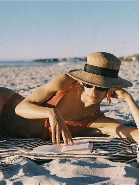 Chapeau en paille + serviette  rayures + bikini + roman passionnant = le bon mix