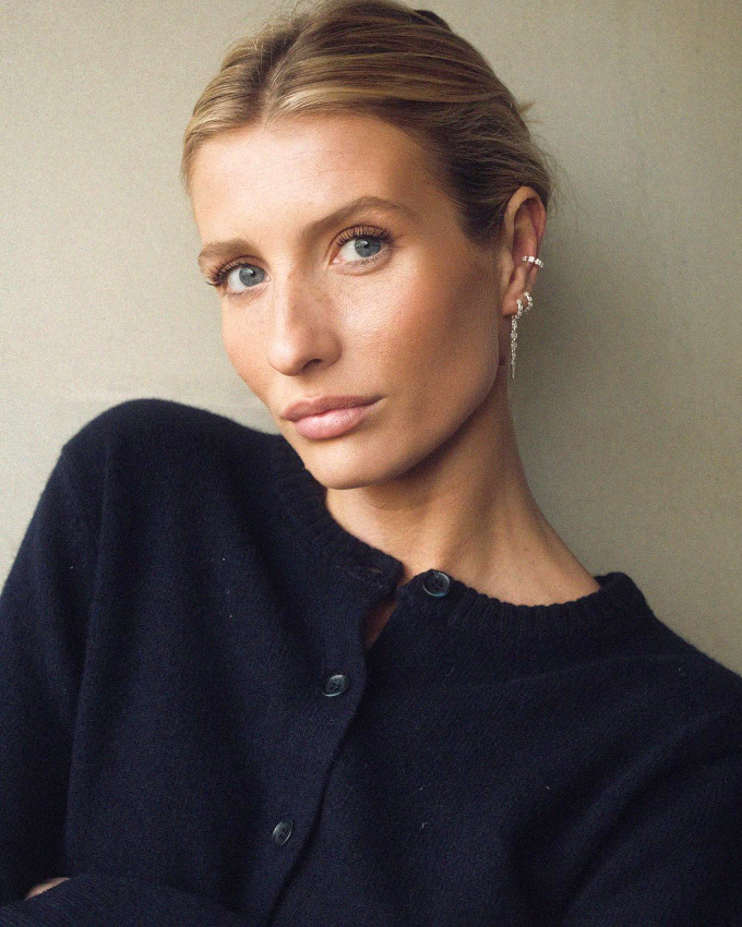 Cardigan bleu marine + accumulation de fines boucles d'oreilles + coiffure sage = le bon mix