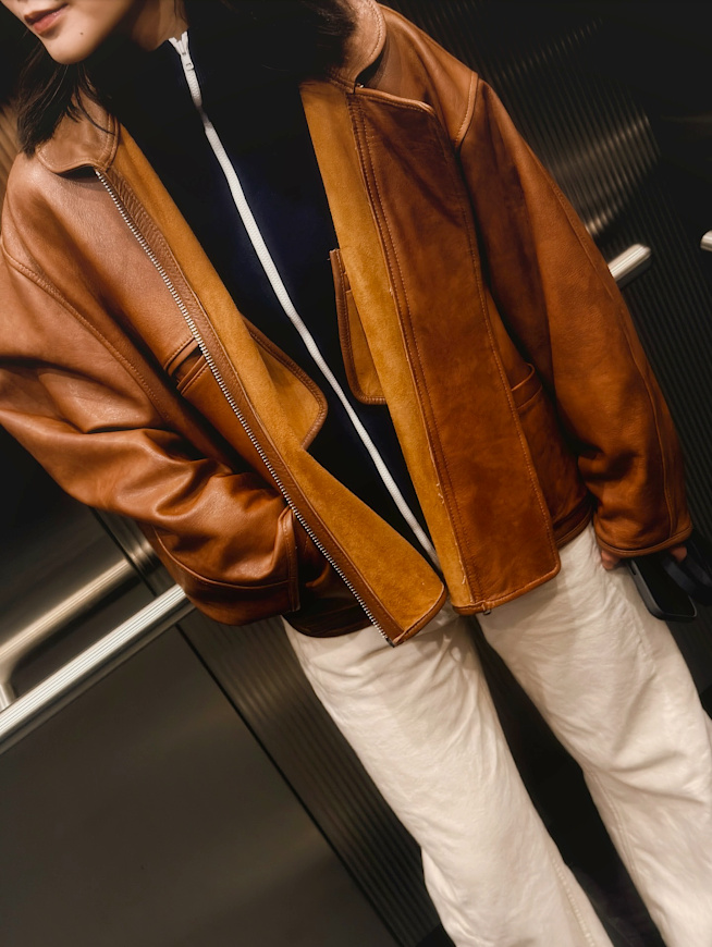 Qui eût cru que veste en cuir fauve et gilet zippé bleu marine feraient si bon ménage ?