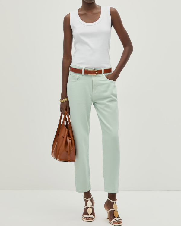 Slim vert d'eau très clair porté avec un débardeur blanc, une ceinture camel, un sac en cuir fauve et des sandales blanches décorées