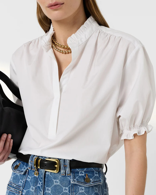 Blouse blanche à col froncé et manches courtes bouffantes portée avec un jean imprimé bleu