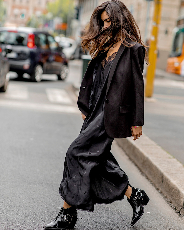 Robe noire fluide portée avec un blazer oversize et des bottines vernies noires